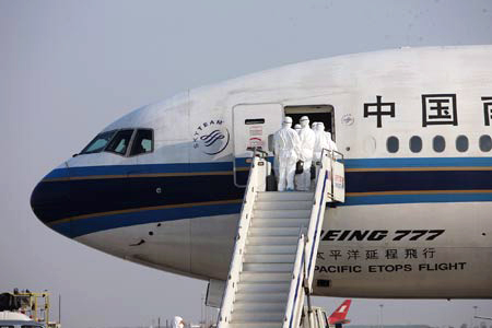 (090506) -- SHANGHAI,   May 6,   2009 (Xinhua) -- Inspectors walk aboard the chartered plane from Mexico to check the health of Chinese citizens from Mexico after the plane arrived in Shanghai on May 6, 2009. The chartered plane sent to fetch Chinese citizens from Mexico arrived in Shanghai Wednesday afternoon, with 98 passengers and 21 crew members on board. (Xinhua/Xing Guangli)