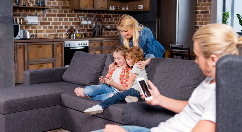 Familj i hemmet med smartphones. Foto: Mostphotos.se