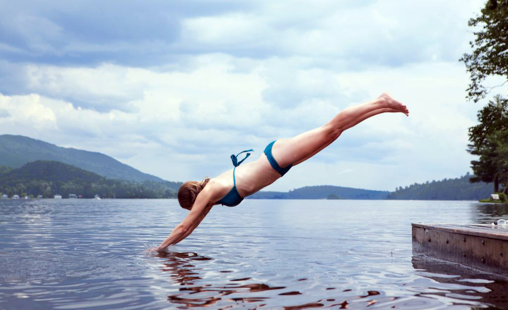 Simmare. En kvinna som hoppar i vatten . Foto: Todd Quackenbush Licens: Unsplash (free use)