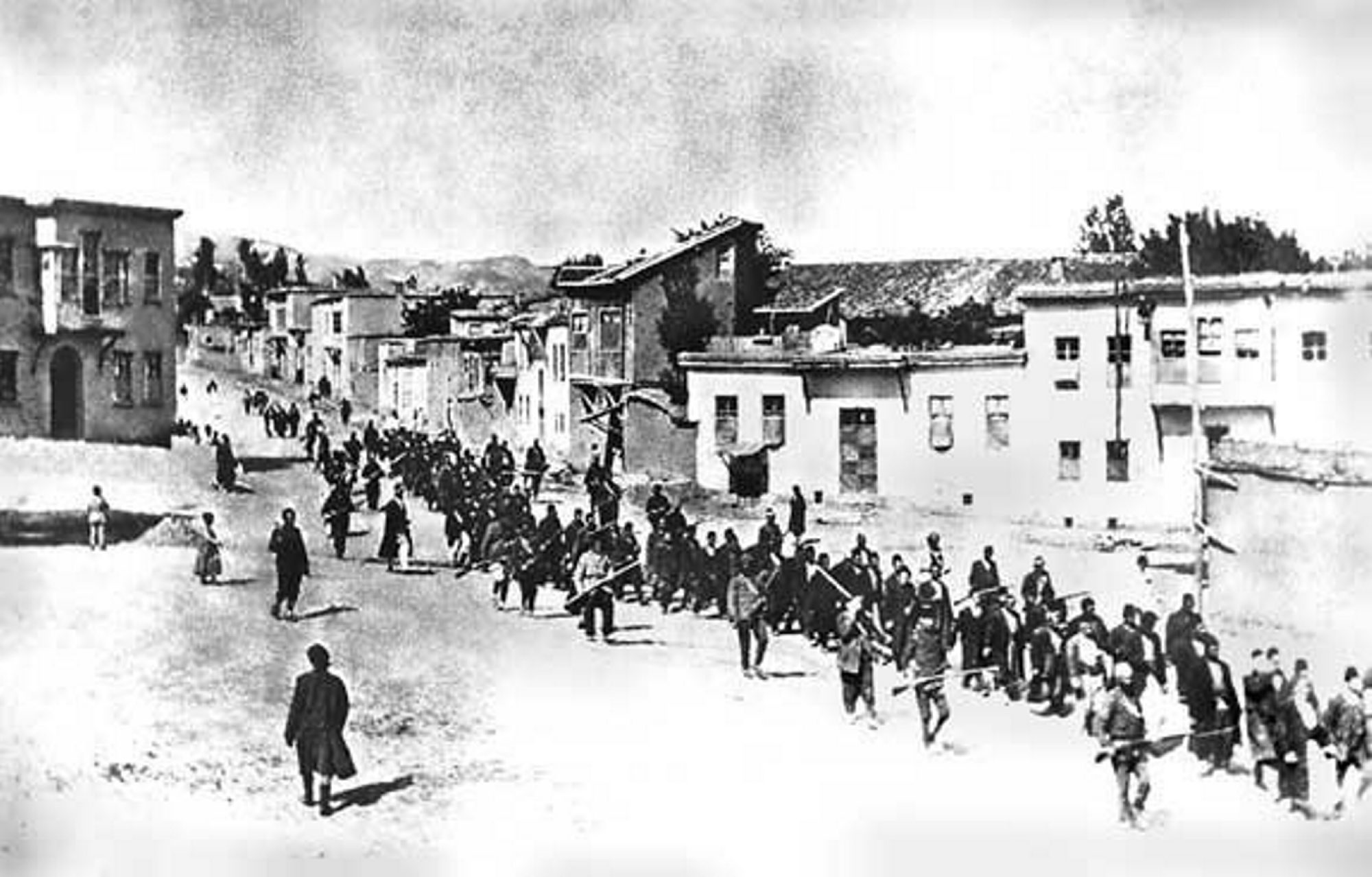 Civila armenier förs till ett närbeläget fängelse i Mezireh av beväpnade turkiska soldater. Kharpert, Osmanska riket, april 1915. Licens: Public Domain